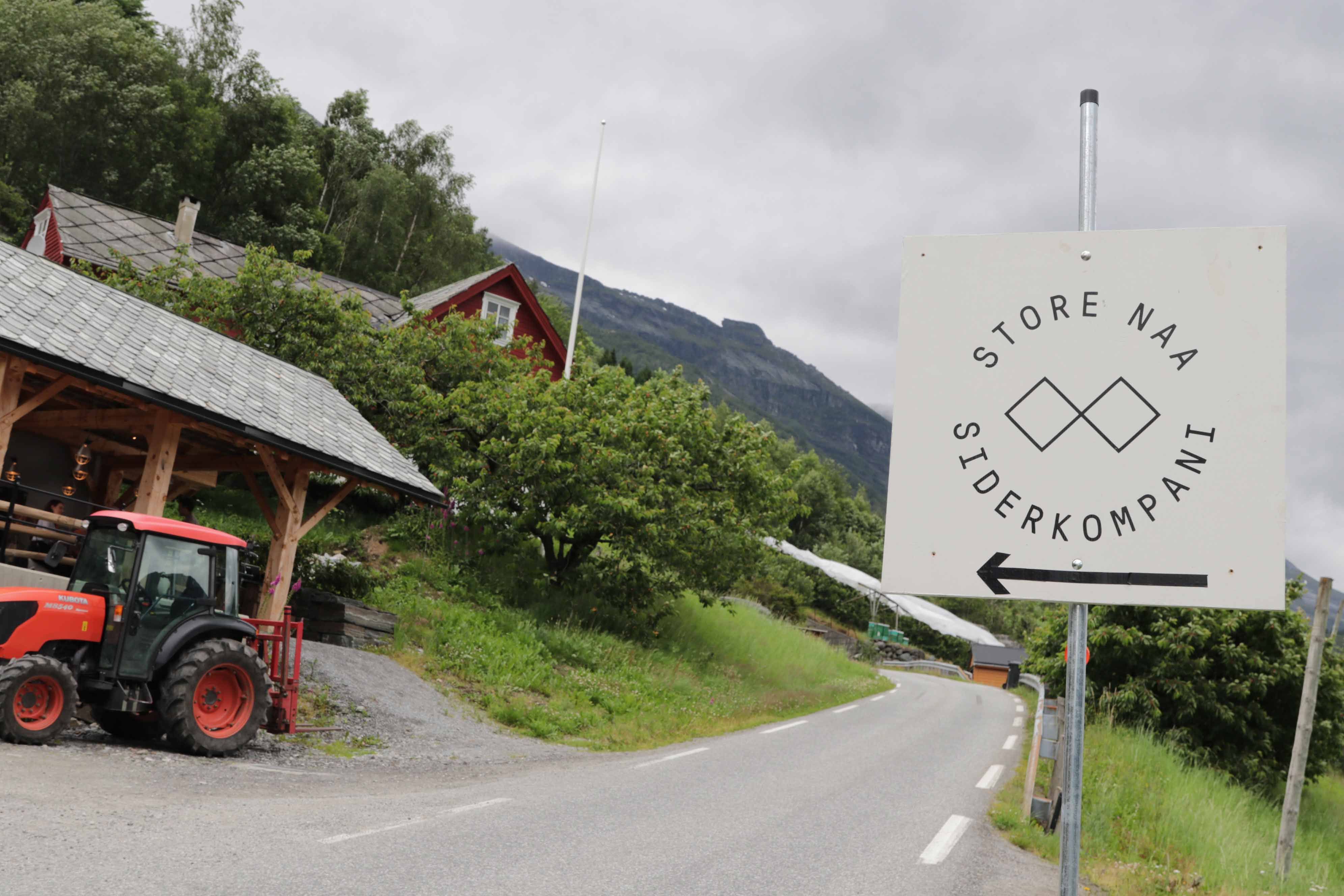 Skilt som peker mot Store Naa Siderkompani langs en landevei i Hardanger.