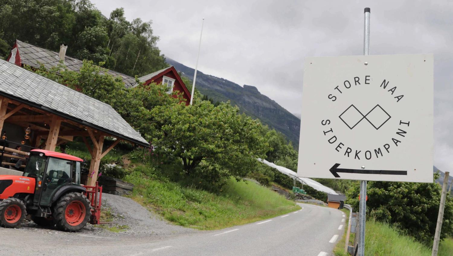 Skilt som peker mot Store Naa Siderkompani langs en landevei i Hardanger.