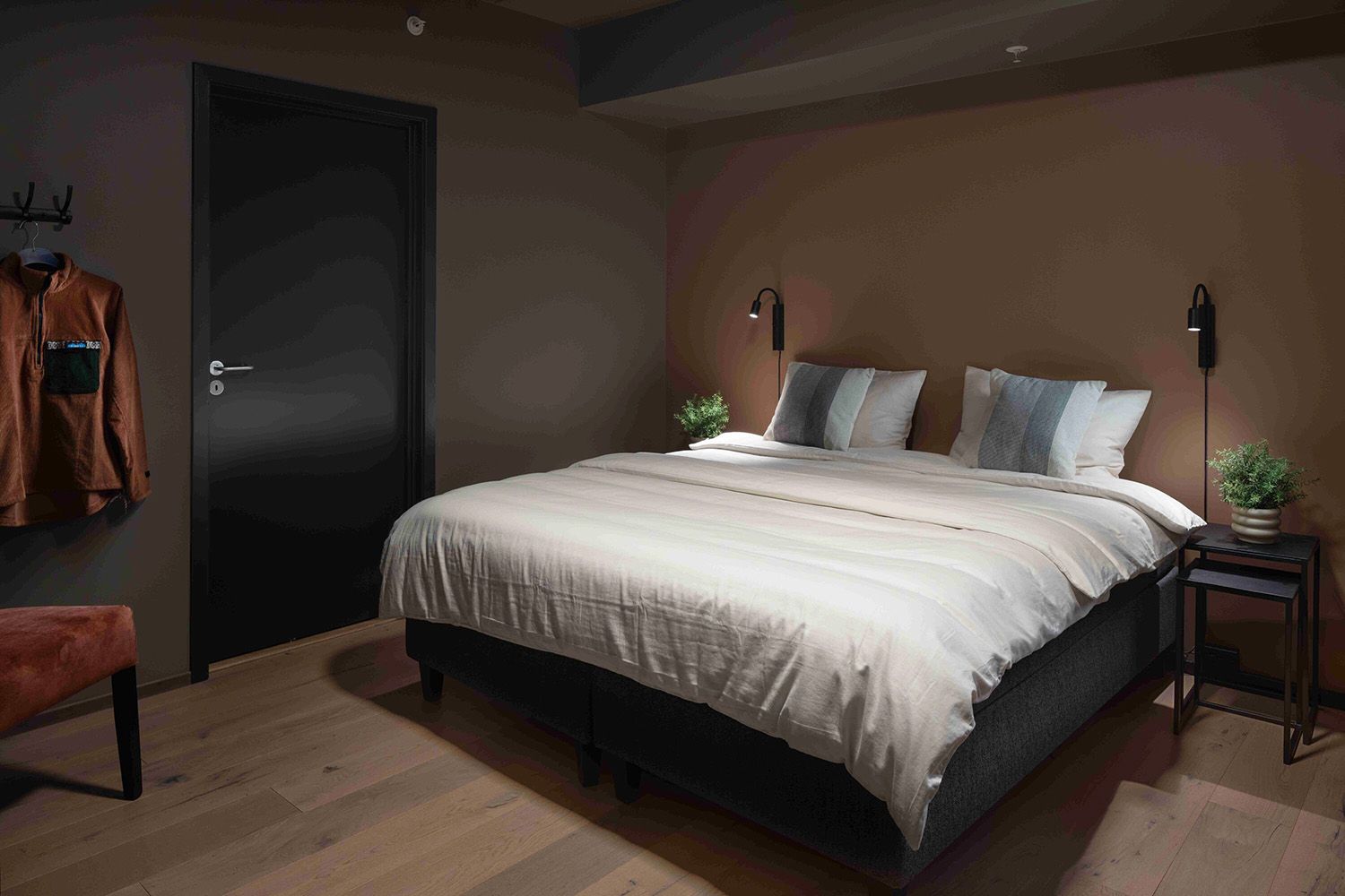 Hotellrom i duse farger med stor dobbeltseng