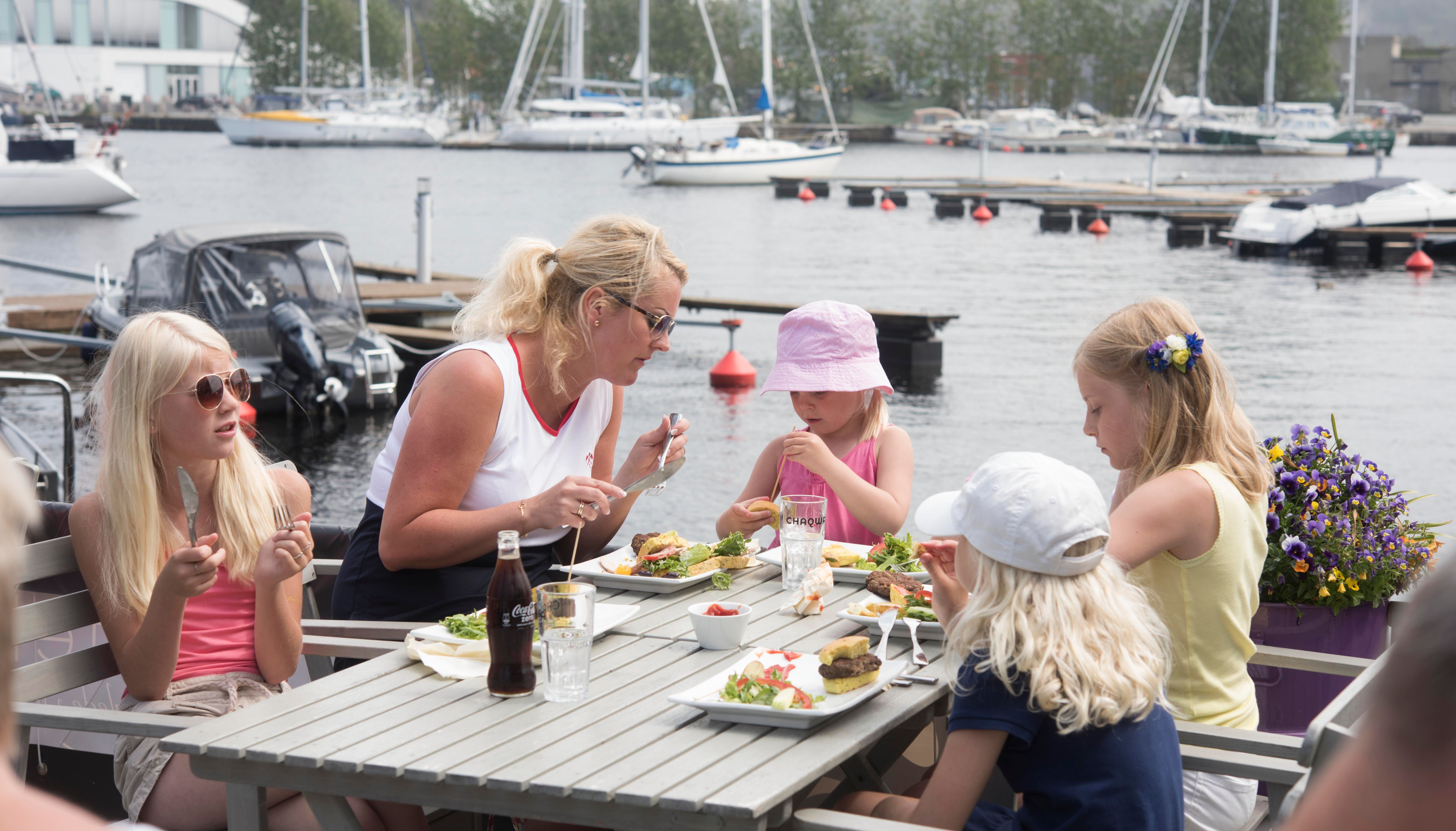 Family of five sitting outside enjoying good food.