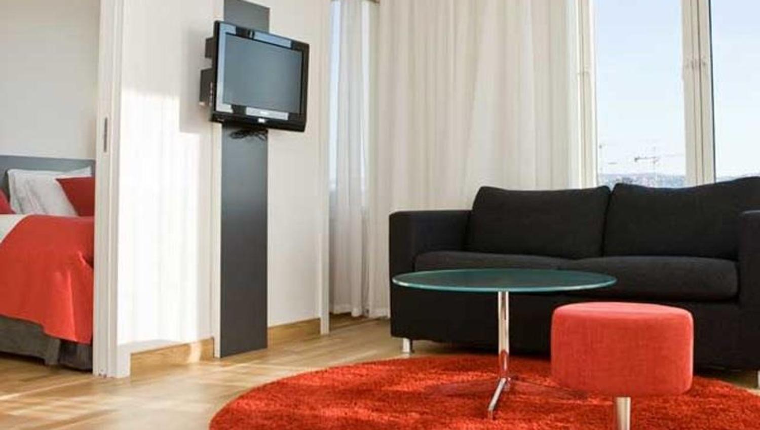 sofa corner with TV, and bed in a separate room