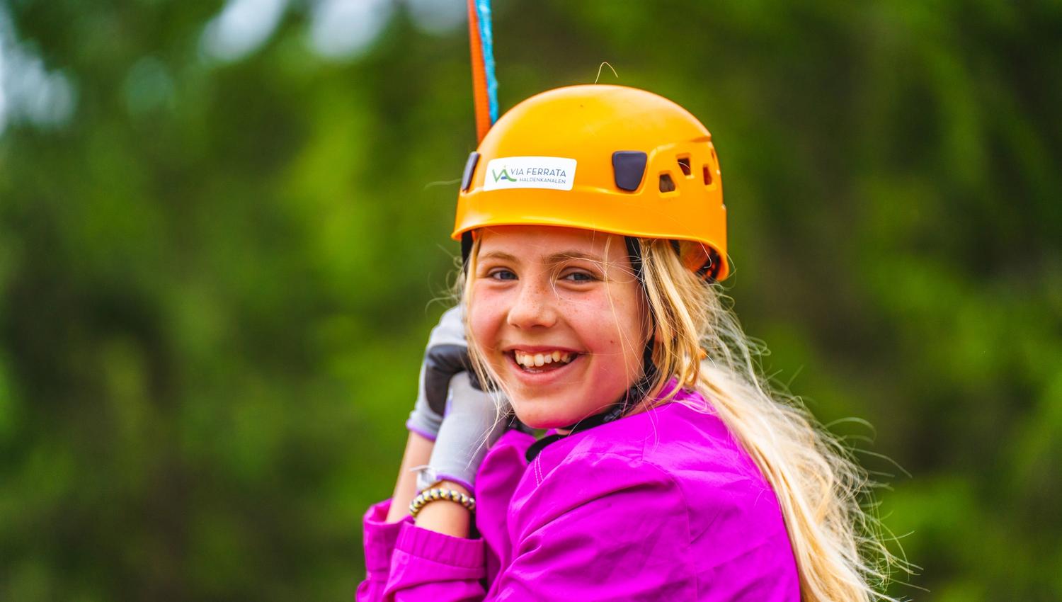 Jente på vei ned i zip-linen i Via ferrata Haldenkanalen
