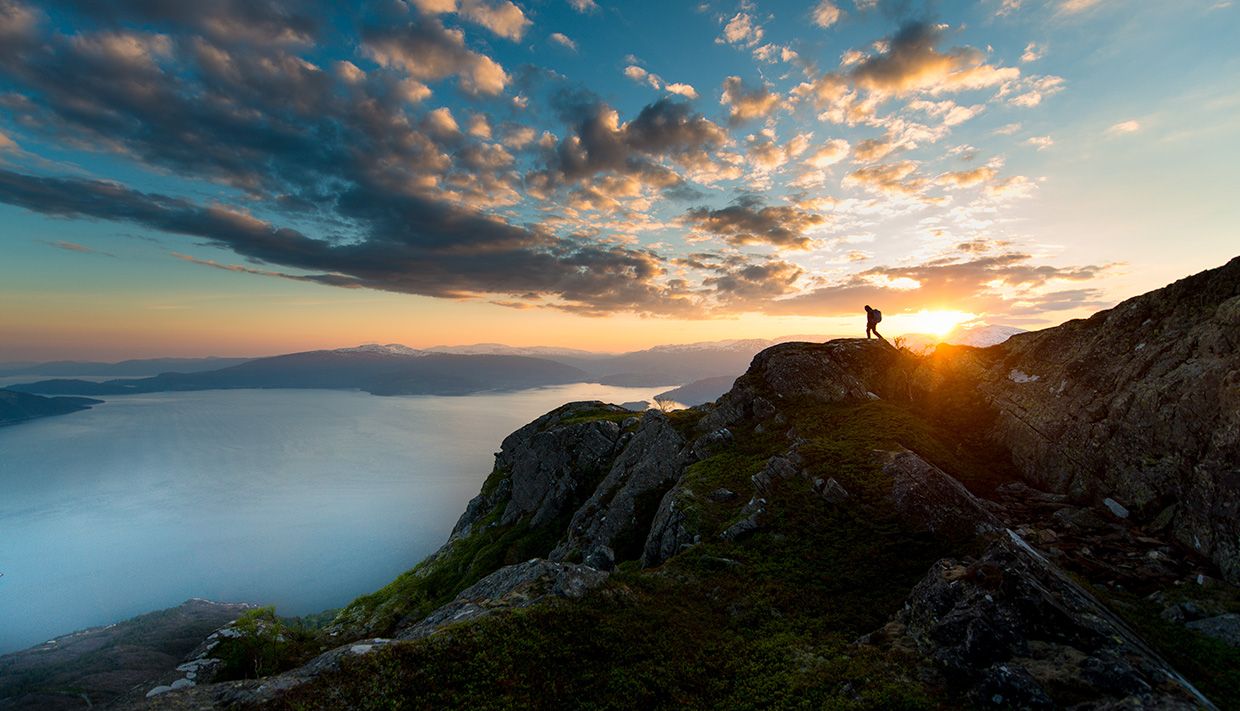 Sunset behind mountain peaks with a fjord view in Hardanger.