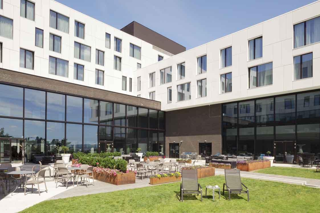 bakgård med plen og mange sitteplasser
