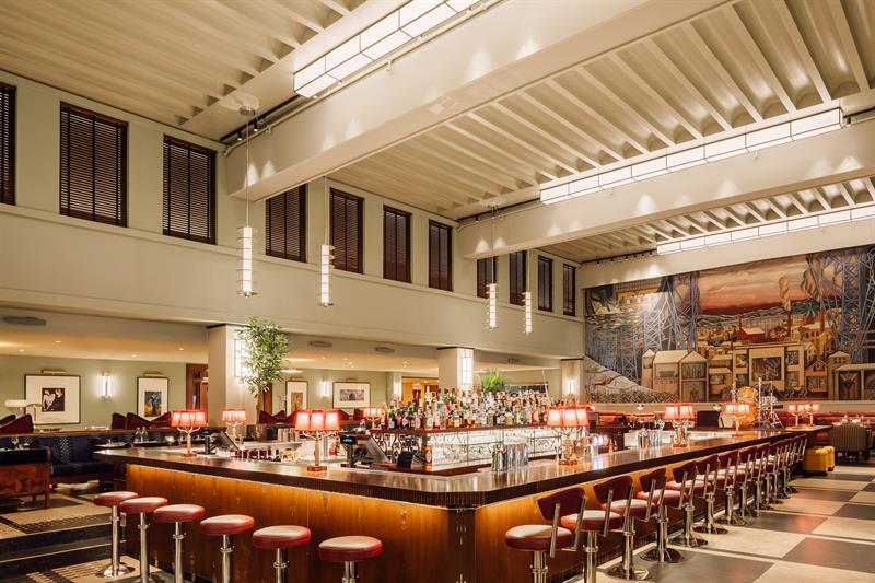 Firkantet bar i sentrum av rommet, freske av Per Krogh langs veggen i enden.