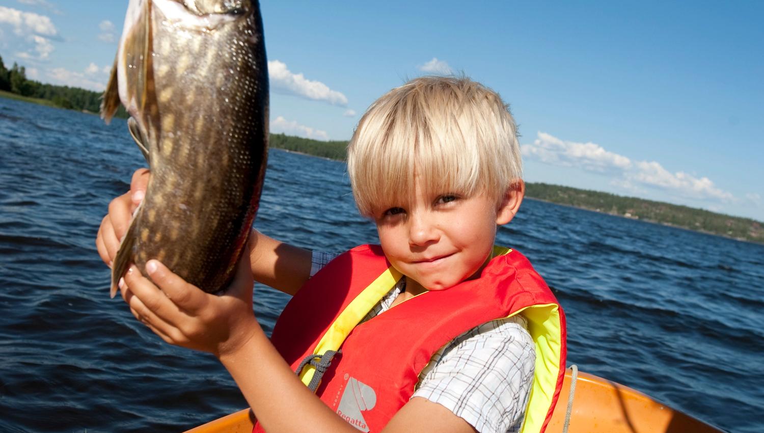 Gutt som holder fisk