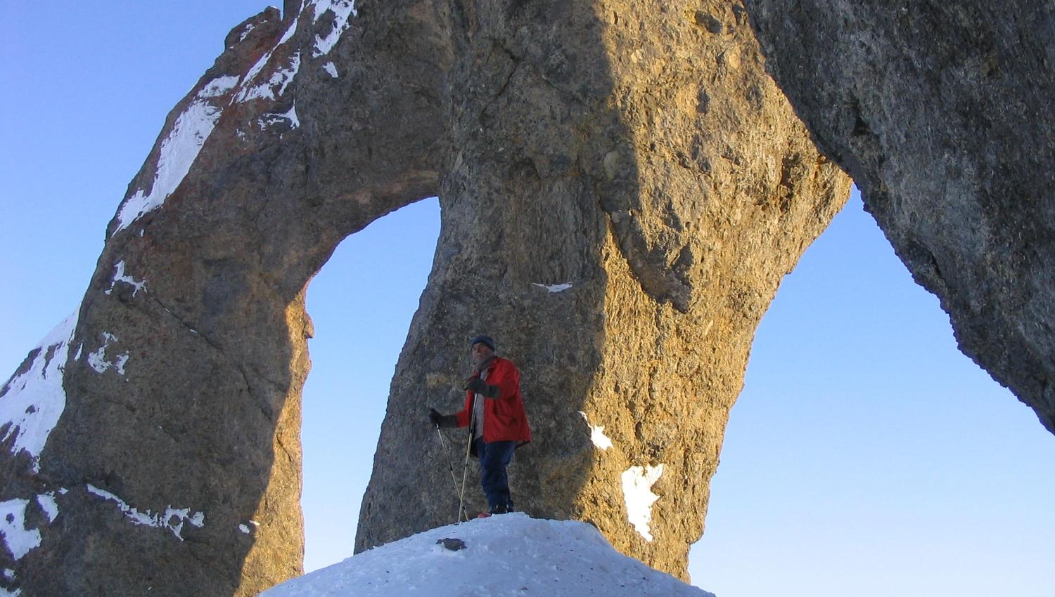 A person standing underneath a mountain formation called Tarantellen / The Tarantula