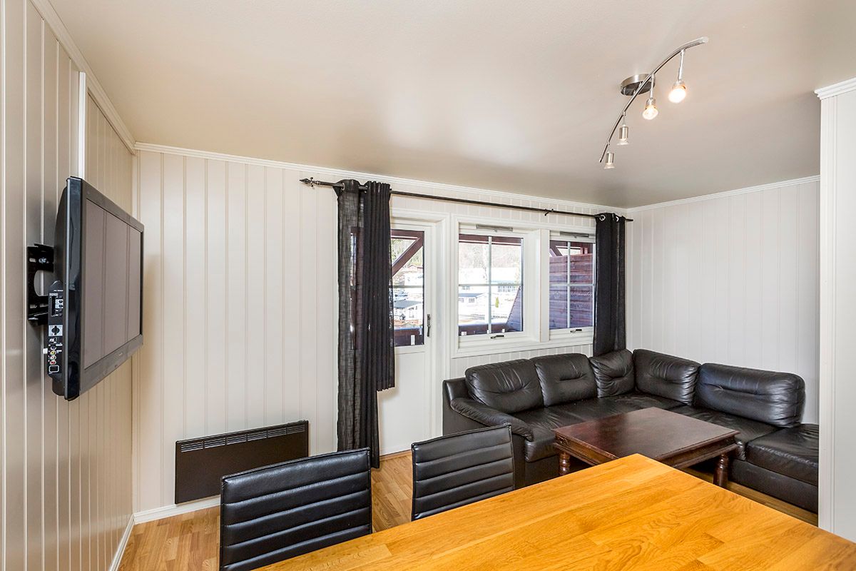 Lounge with a sofa corner, dining table and TV on a campground