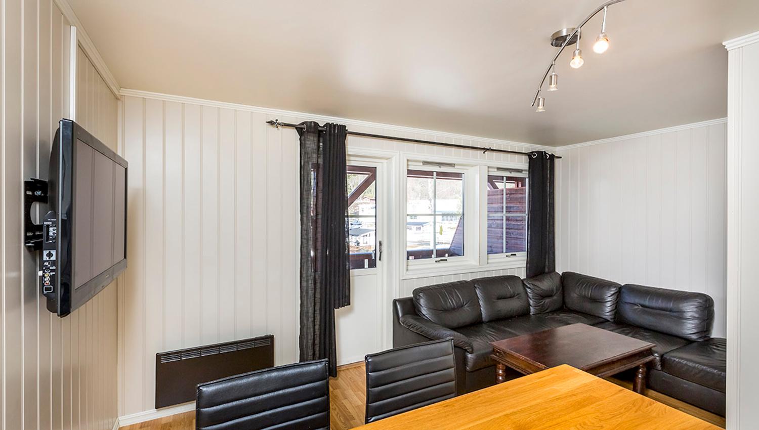 Lounge with a sofa corner, dining table and TV on a campground