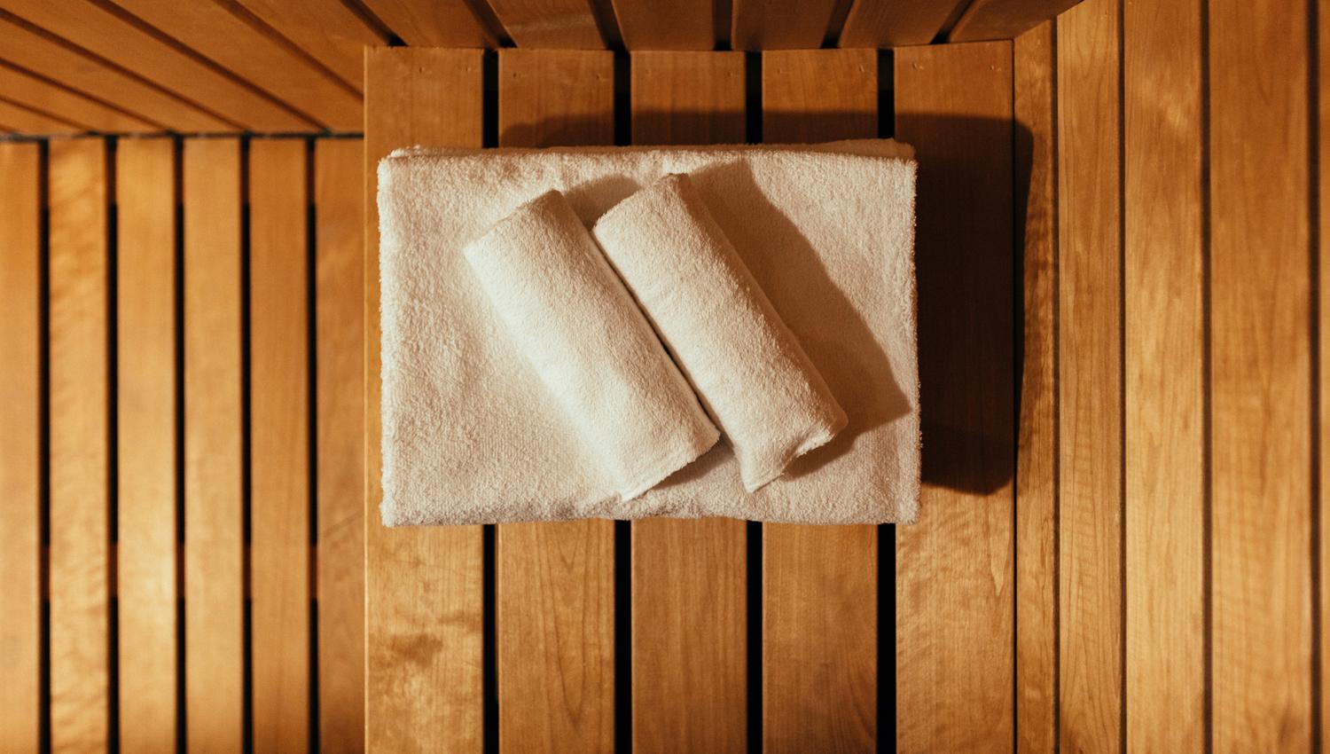 Sauna at Hardanger House with wooden interior and towels ready for relaxation.