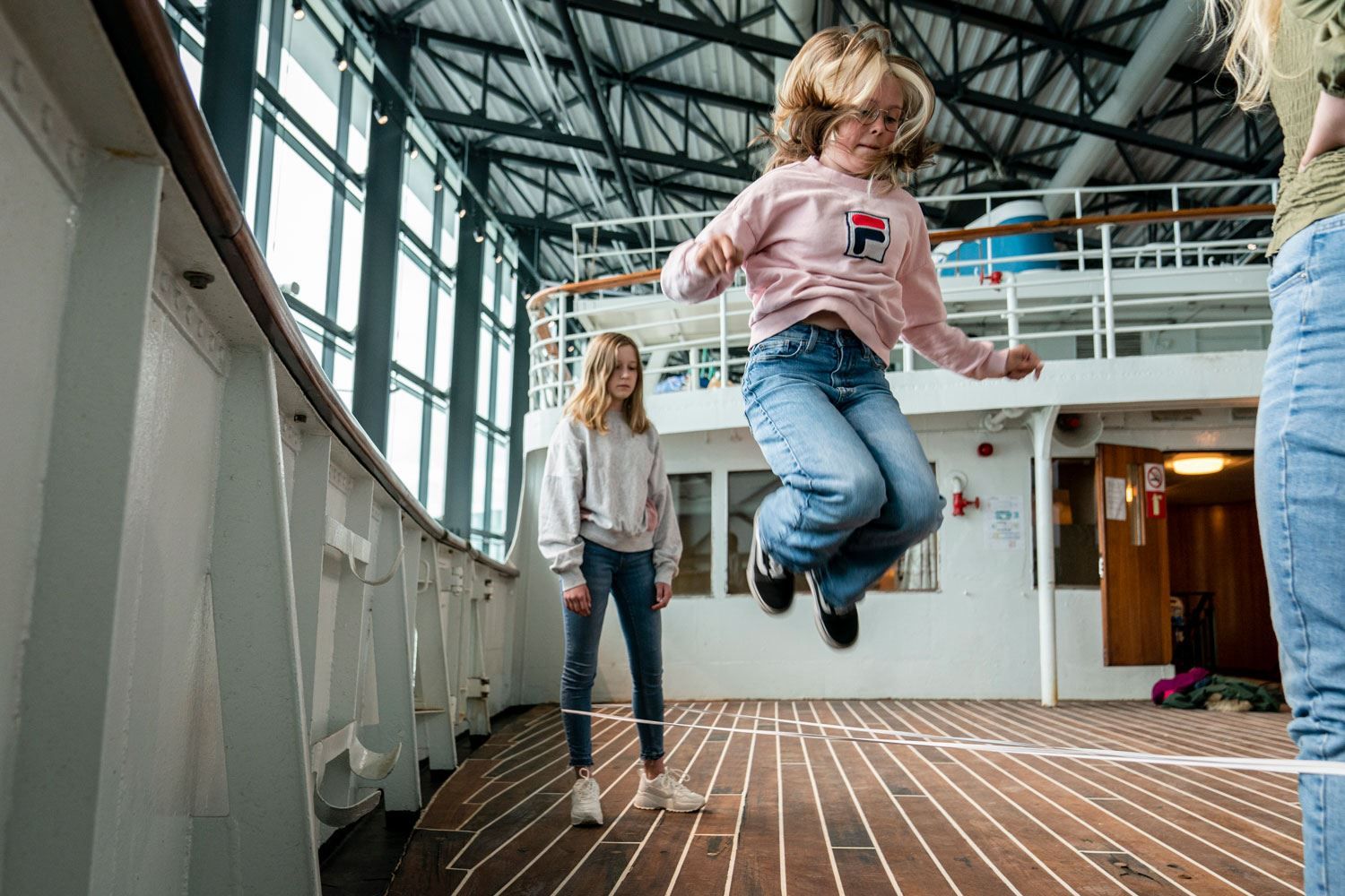 Jenter sprenger i hoppetau på dekket av MS Finnmarken