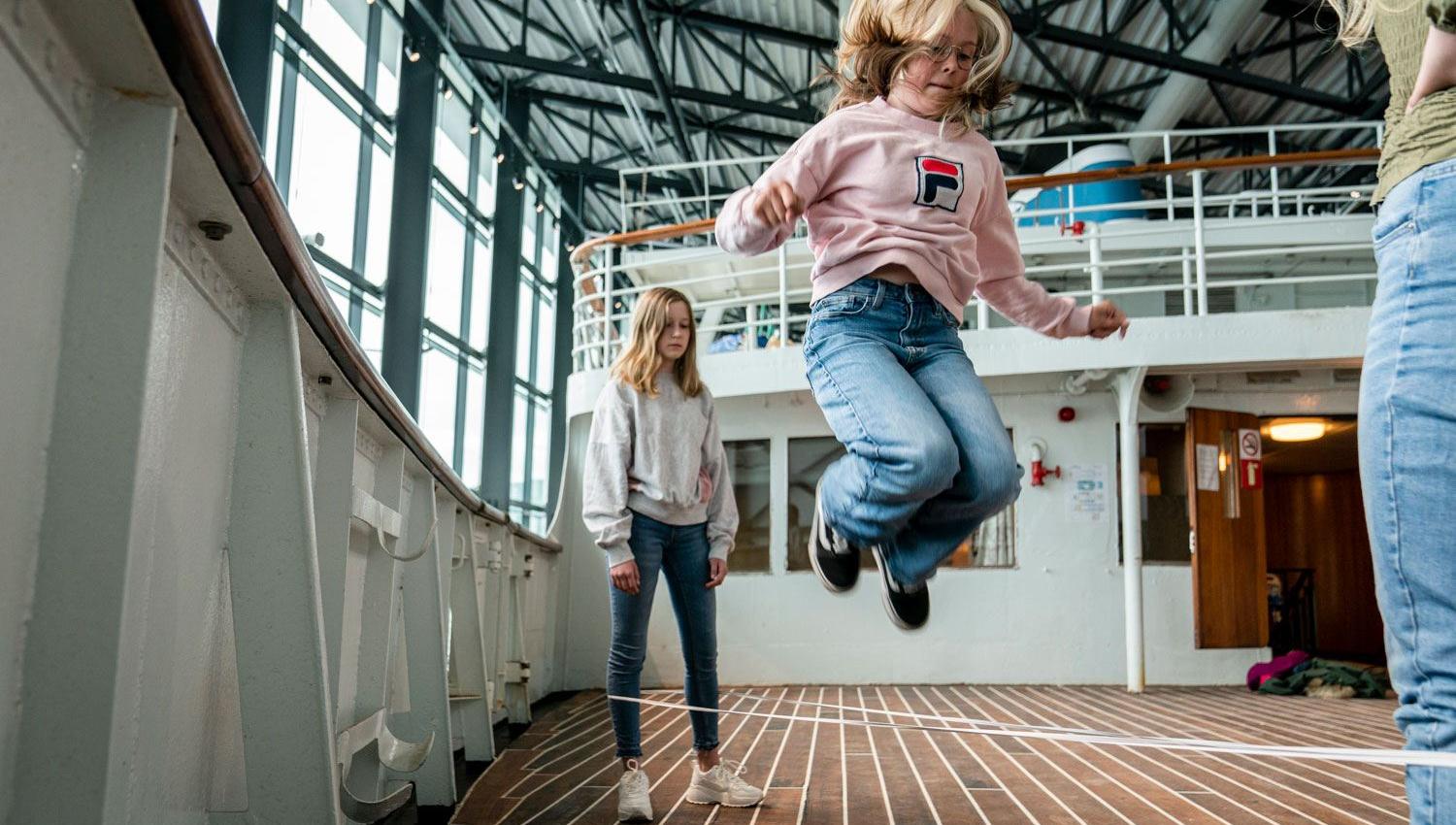 Jenter sprenger i hoppetau på dekket av MS Finnmarken