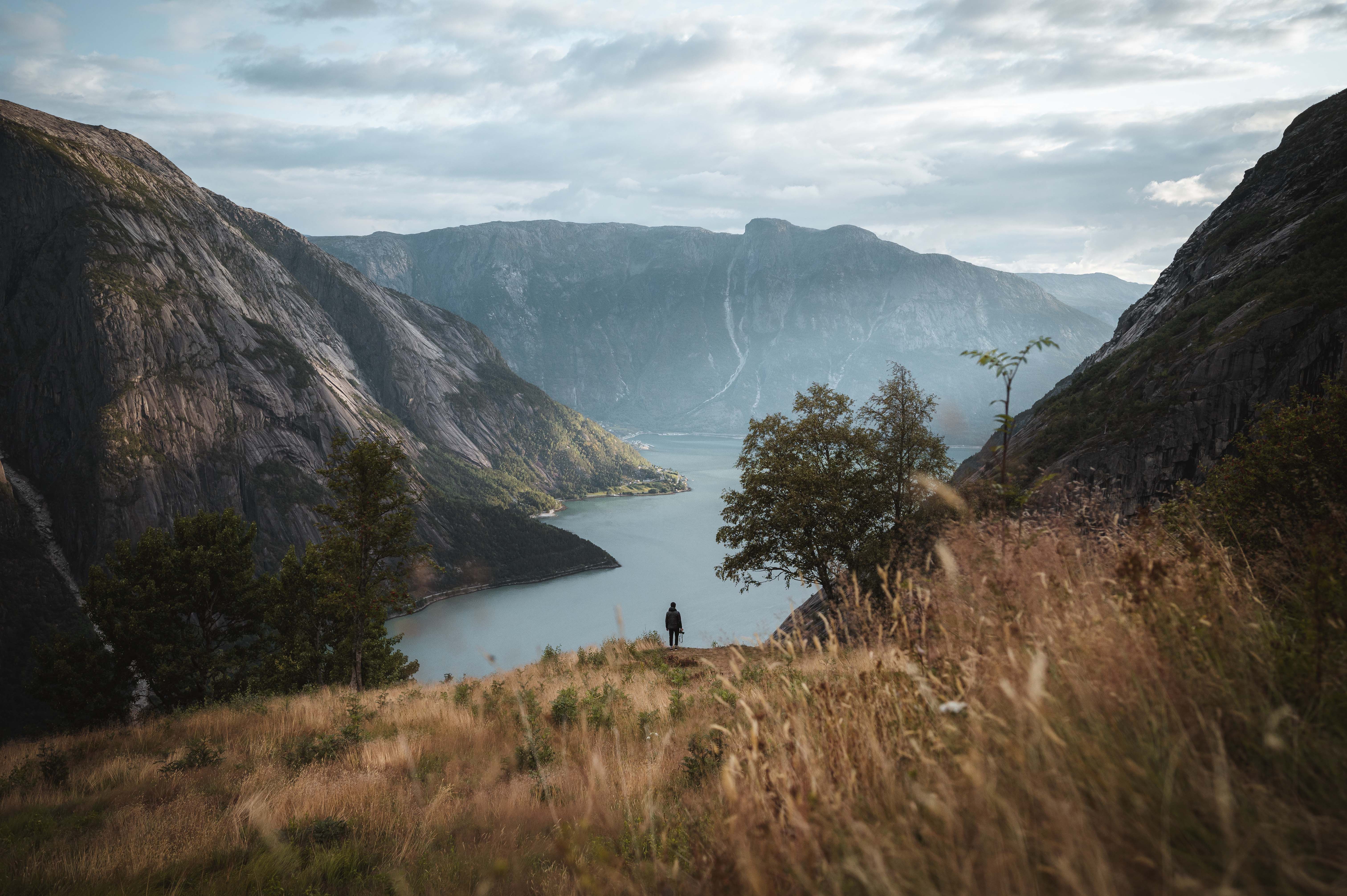 Et bilde fra Kjeåsen som viser en person som står i det fjerne og stirrer på fjorden nedenfor.