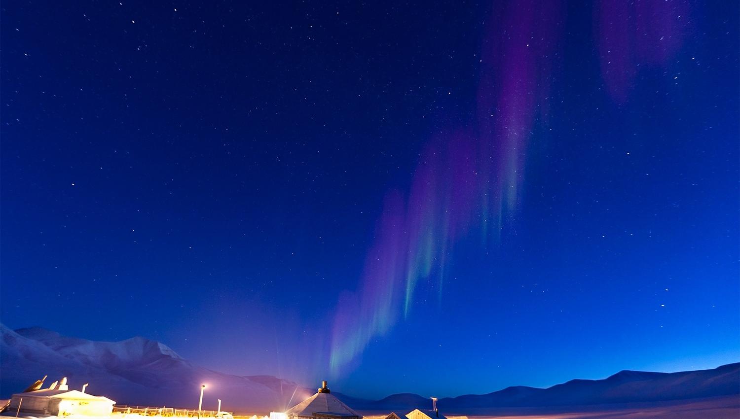 Faint northern lights shining above Camp Barentz
