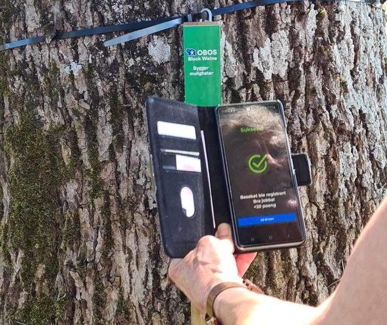 Bilde av en person som scanner koden på stolpen med mobiltelefonen sin