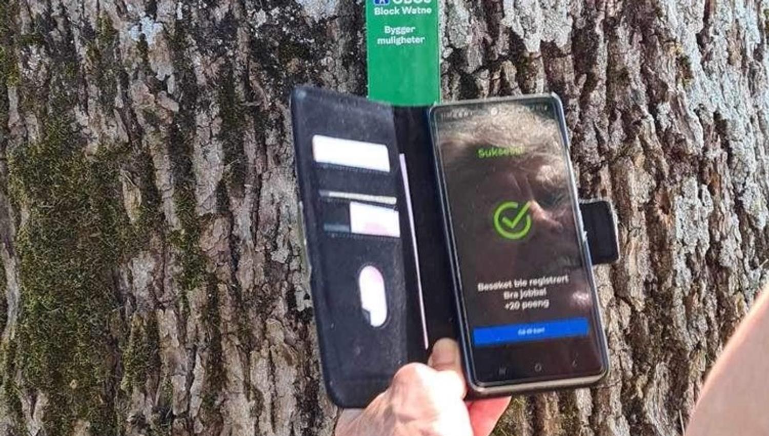 Bilde av en person som scanner koden på stolpen med mobiltelefonen sin
