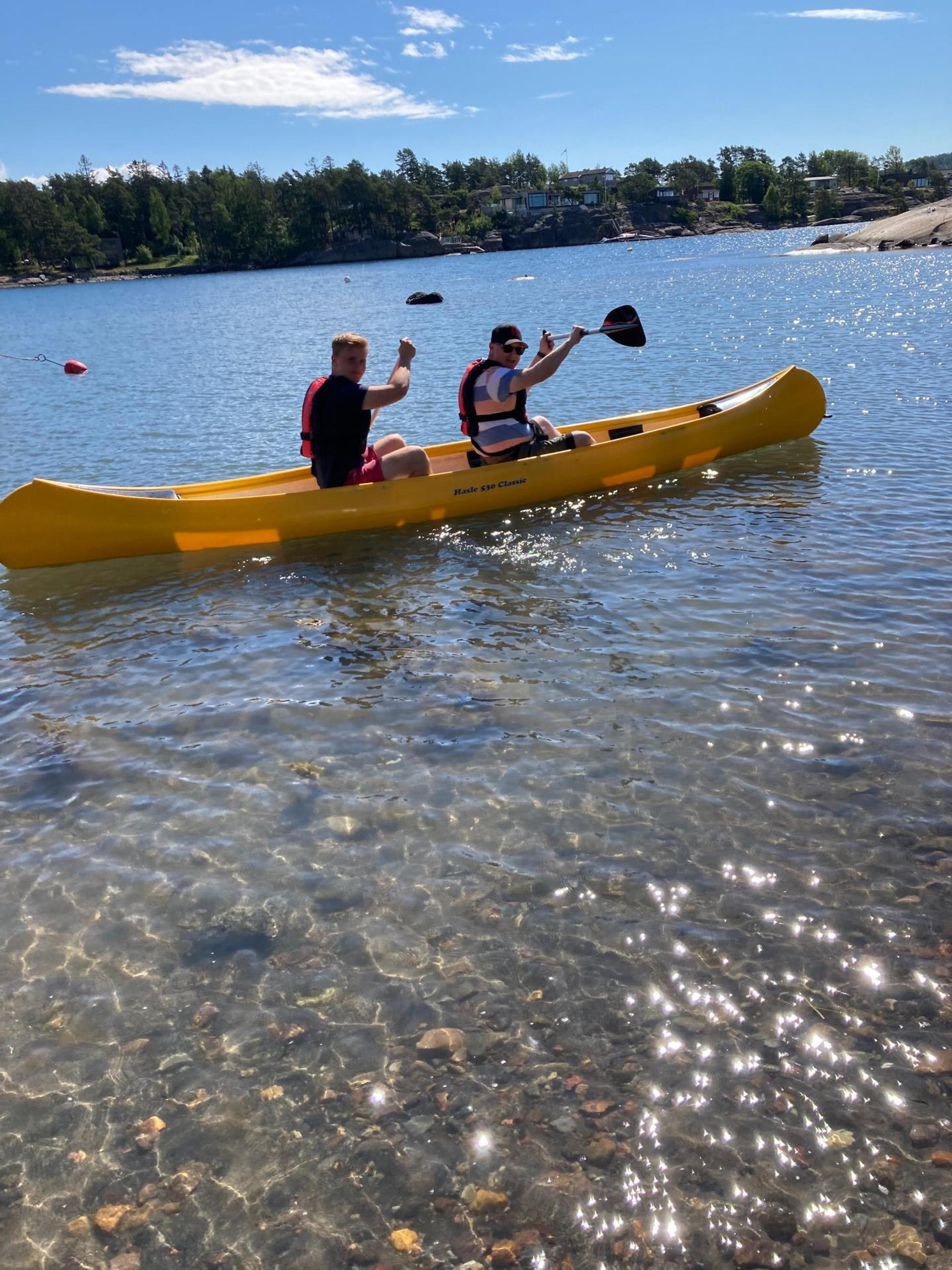 Two paddle in a yellow canoe