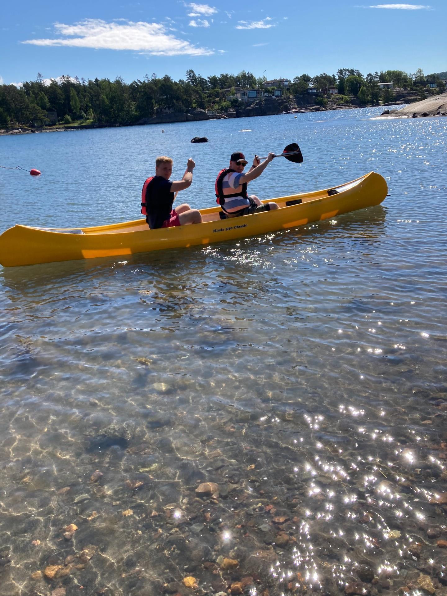 Two paddle in a yellow canoe