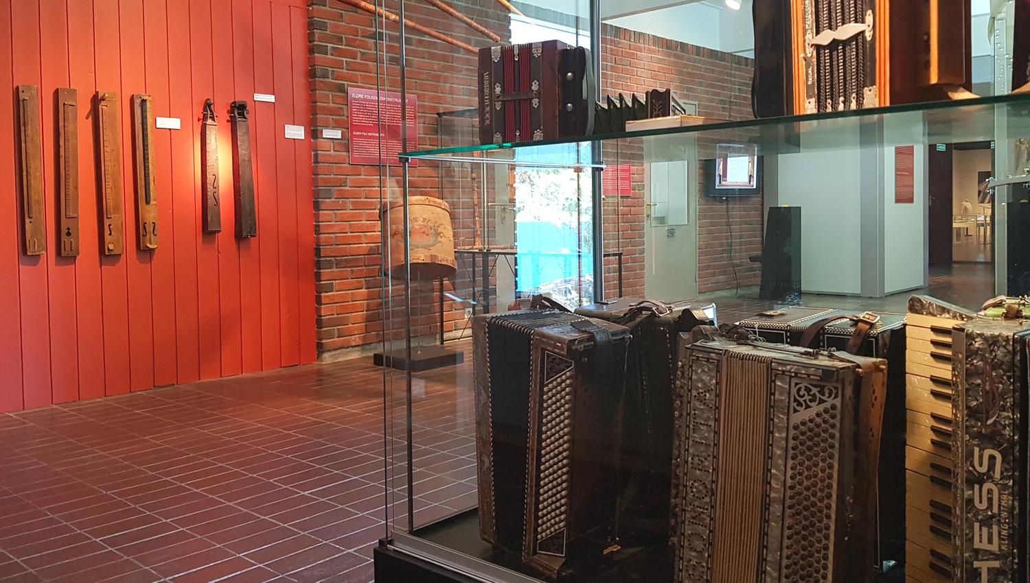Utstilling med gamle folkemusikkinstrument, mellom anna hardingfeler og trekkspel, på Hardanger folkemuseum.