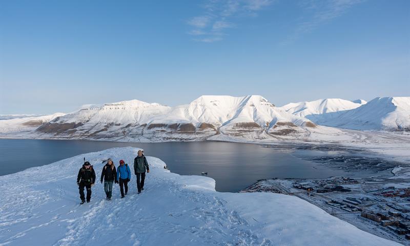 several people hiking on top of the snowcovered mountain 