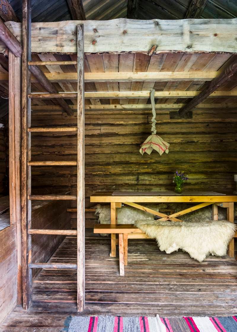 innsiden av et gammelt stabbur med en benk og hems