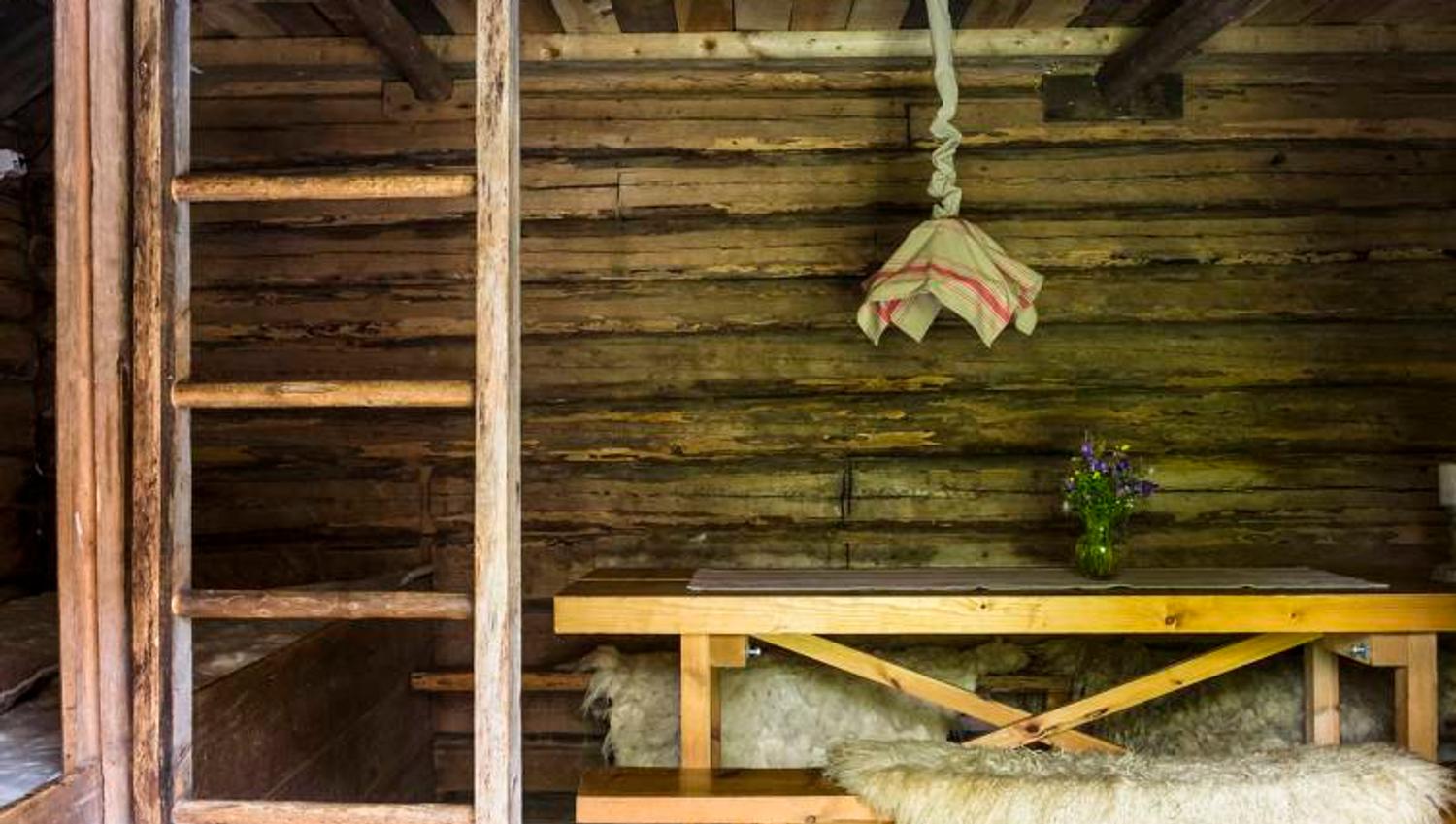 innsiden av et gammelt stabbur med en benk og hems