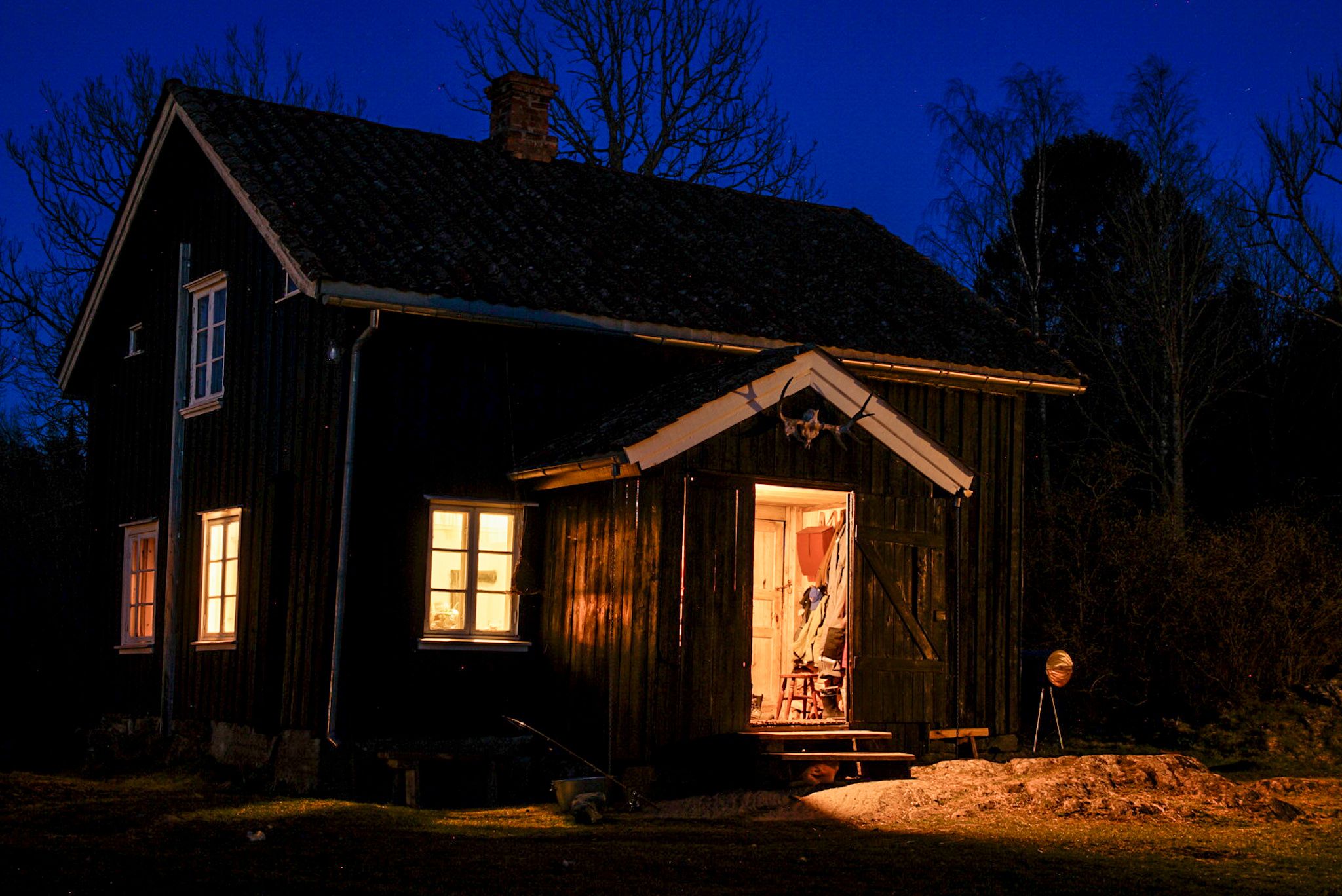 an old farm house lit up in the dark 