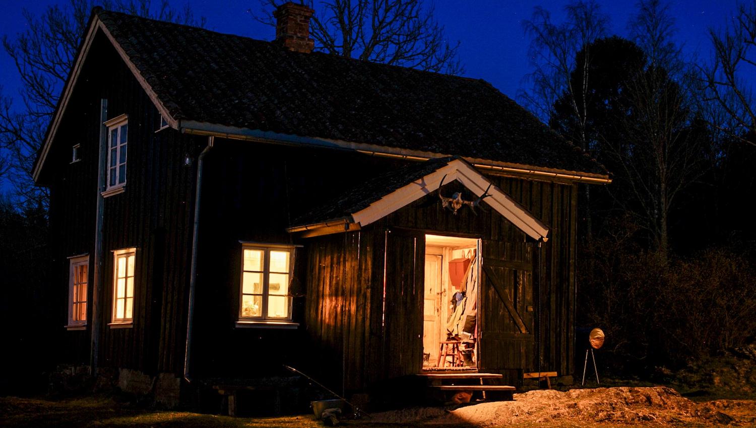 an old farm house lit up in the dark