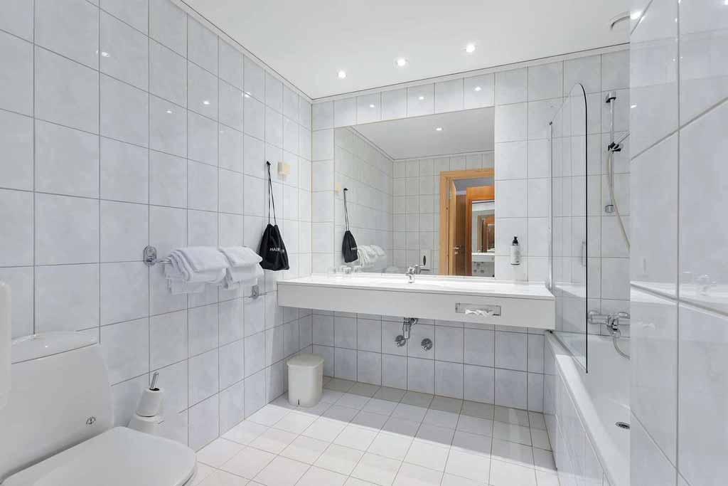 Lyst bad med stor spegel og moderne fasilitetar på Kinsarvik Fjordhotel.