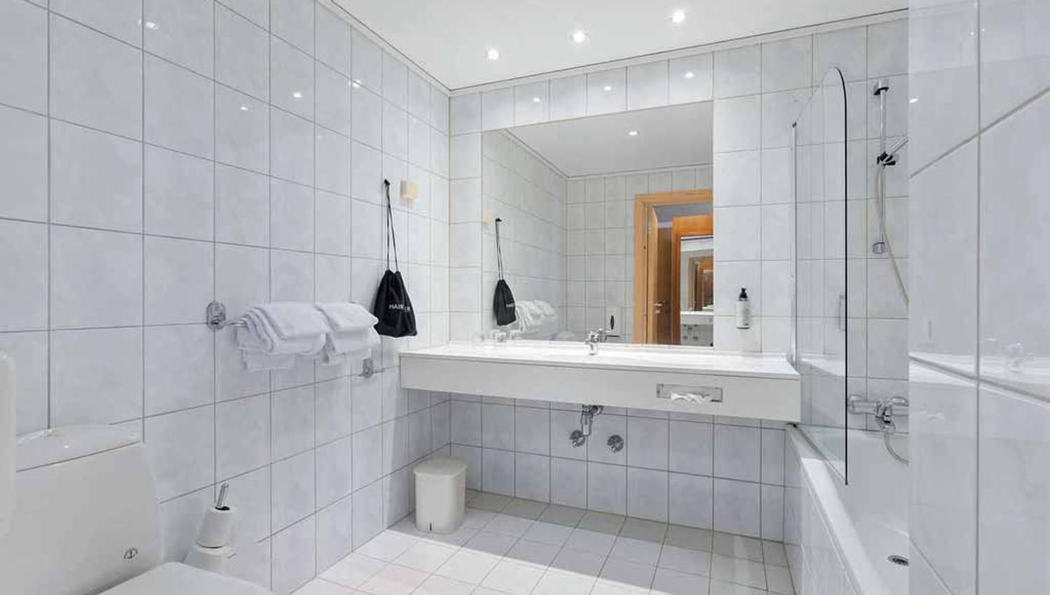 Lyst bad med stor spegel og moderne fasilitetar på Kinsarvik Fjordhotel.