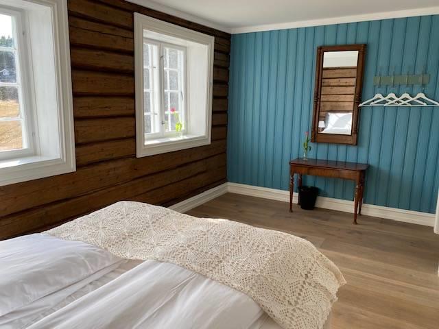 Blue room with double bed, a small table with mirror