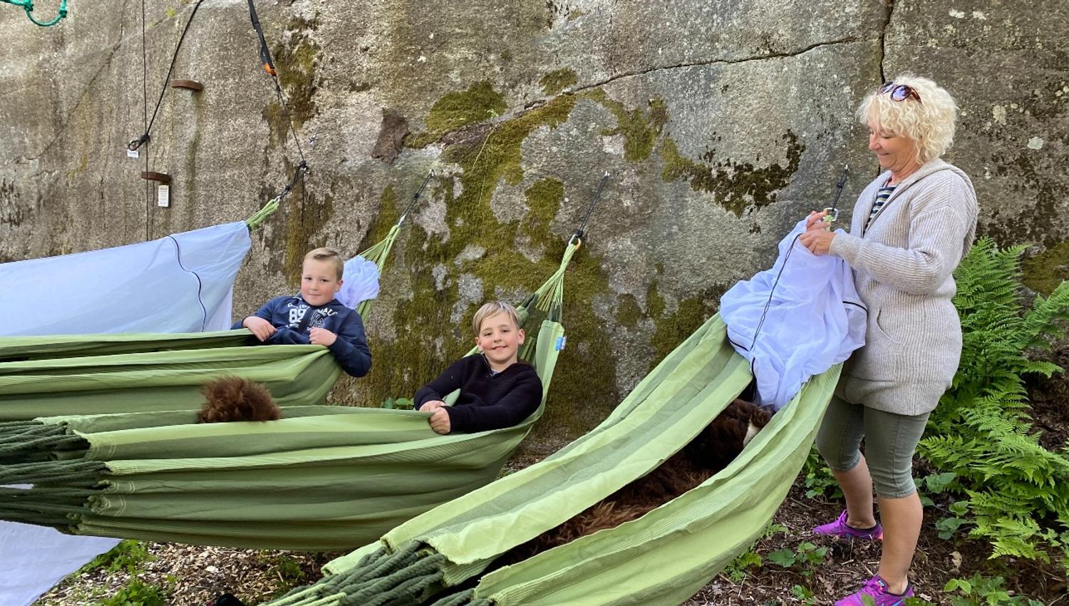 En mor med to barn gjør seg klare for å sove i hengekøyer