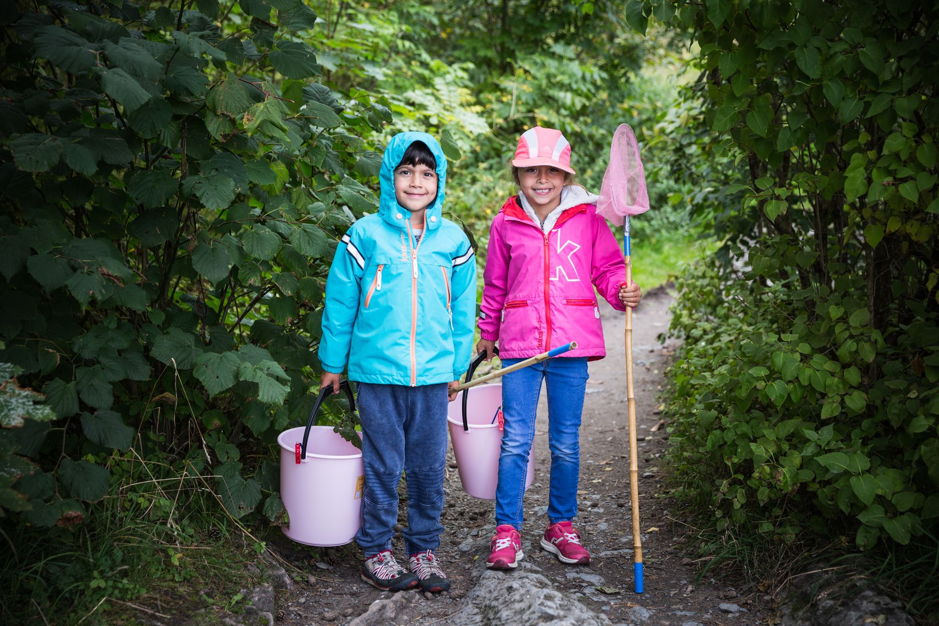 Two kids fishing, green forest