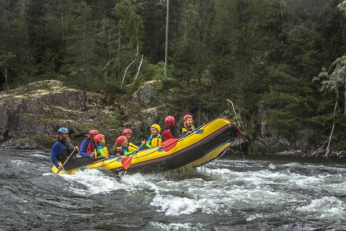 Family rafting on a river with children in the raft