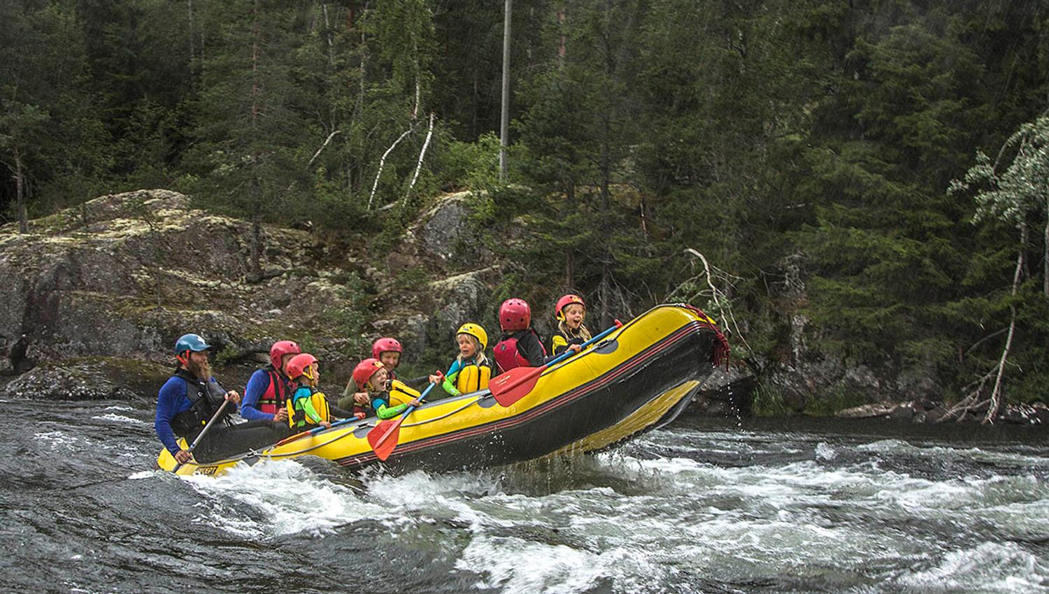Family rafting on a river with children in the raft