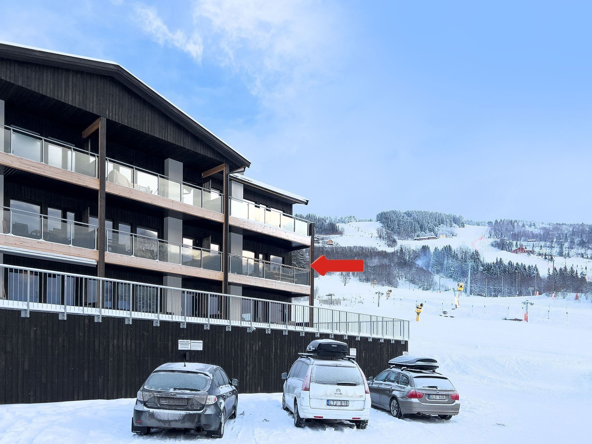 Cars parked cars in the snow.