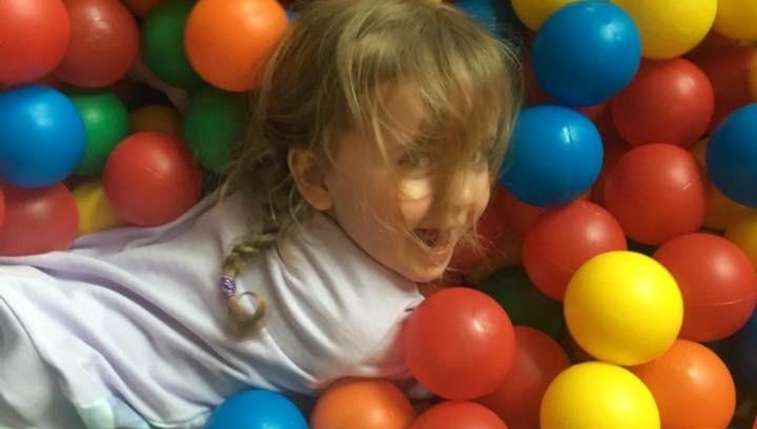 Liten jente leker i ballbinge