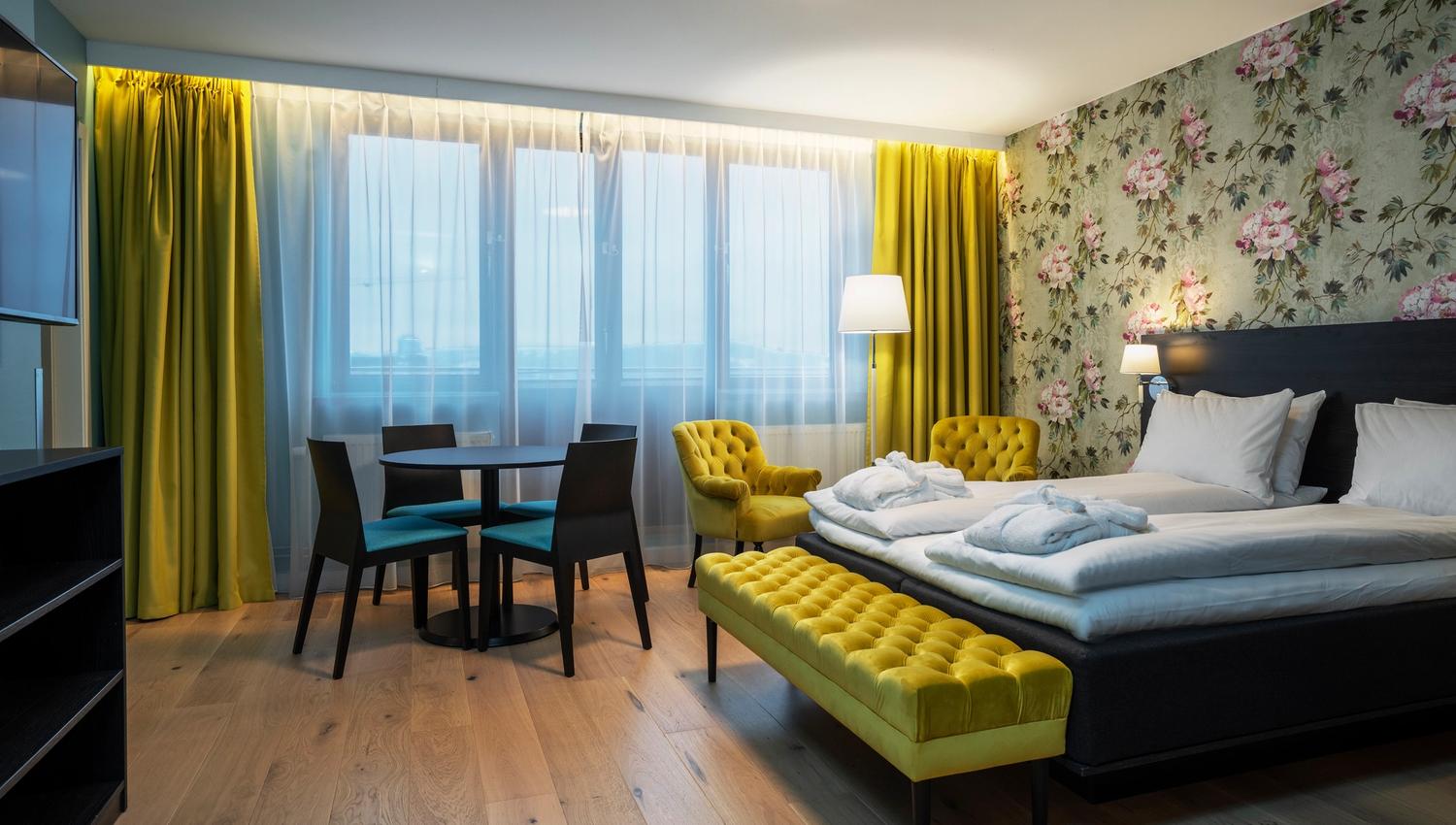 Rom med dobbetseng. Møblement og gardiner i gult.Tregulv. Thon Hotel Slottsparken, Oslo. Foto