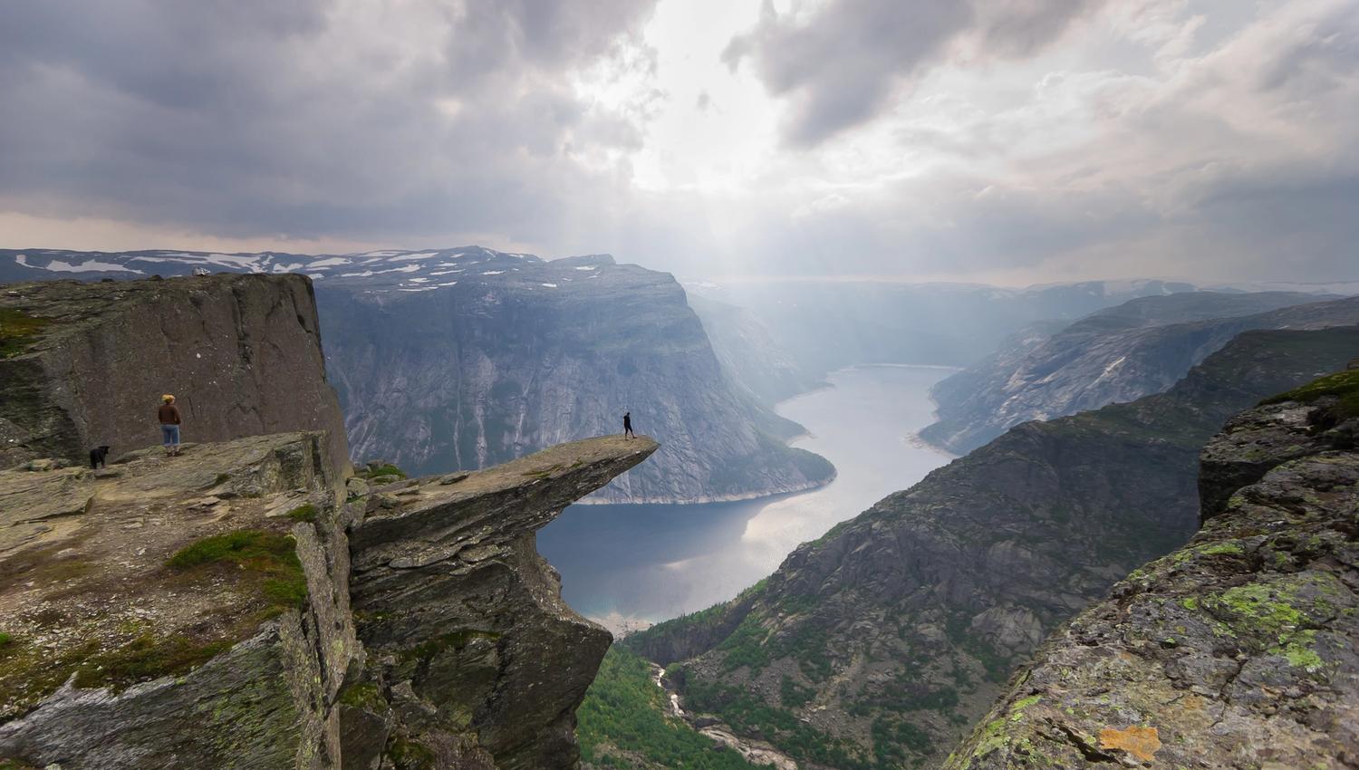 Trolltunga badar i dramatisk lys over Hardangerfjorden, ein ikonisk destinasjon for eventyrlystne turgåarar.