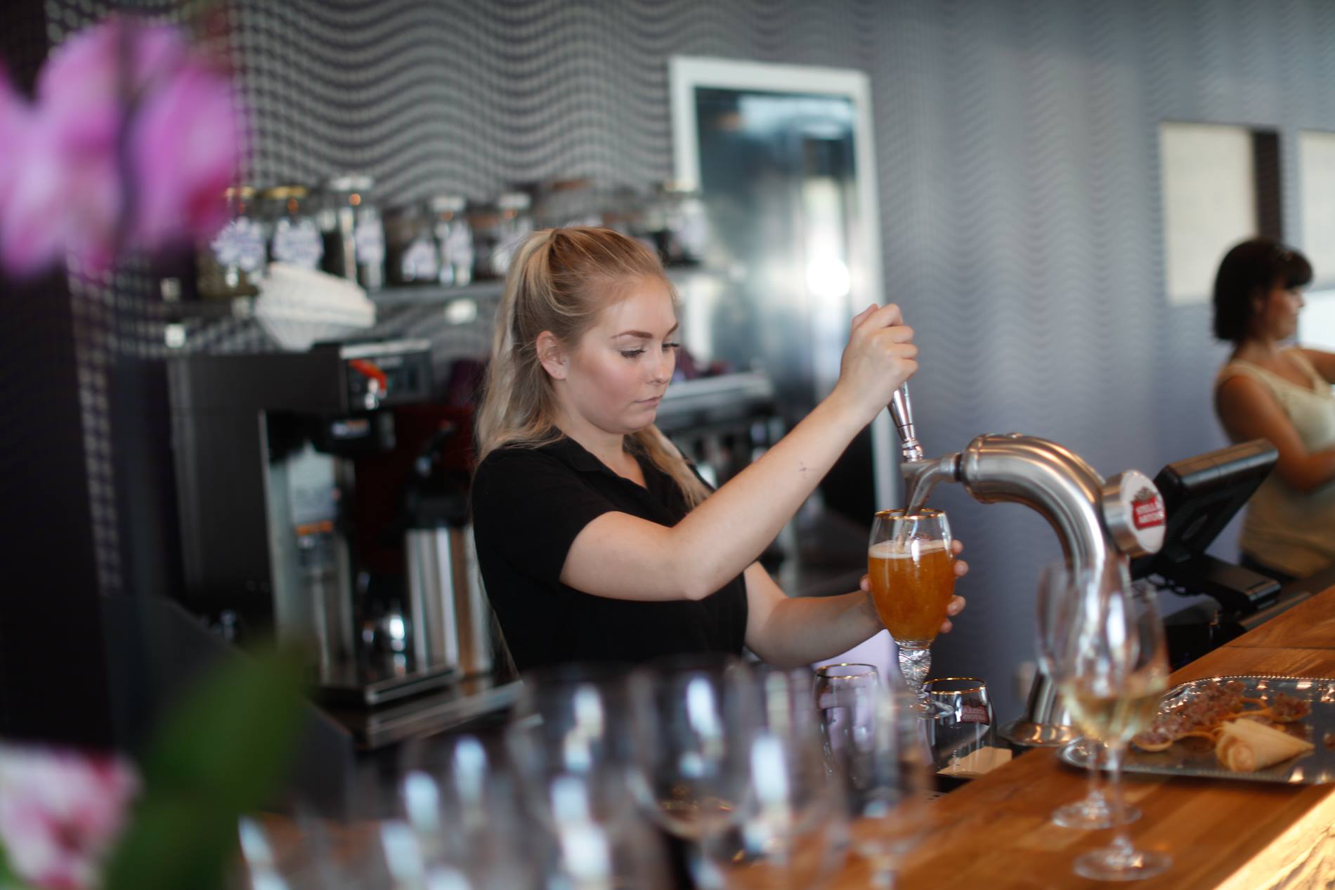 An employee pouring beer into a glass.
