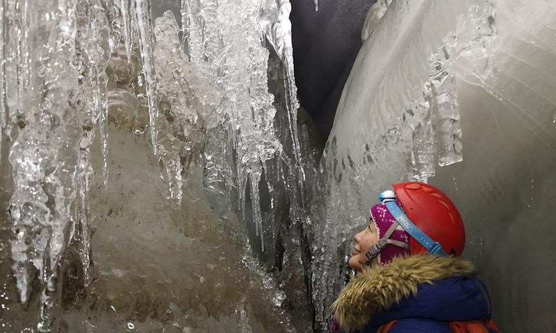 En person som beundrer isgrotte formasjonene