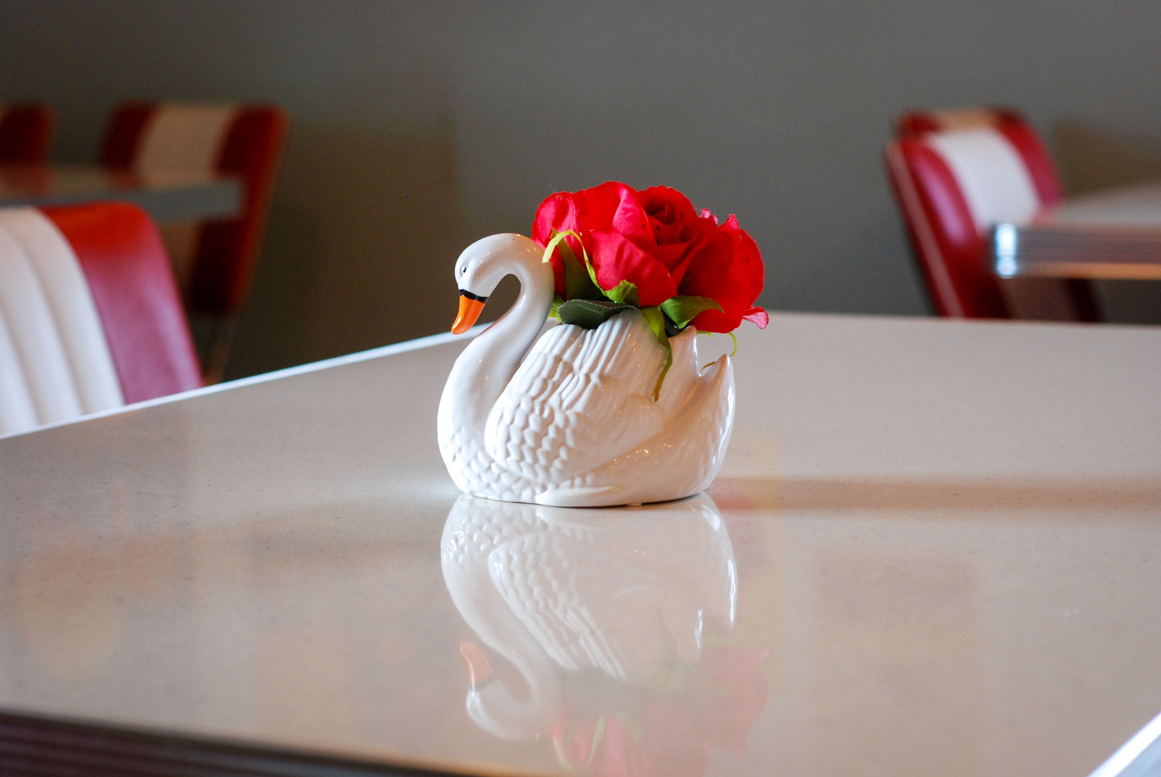 A swan made of glas with a red rose
