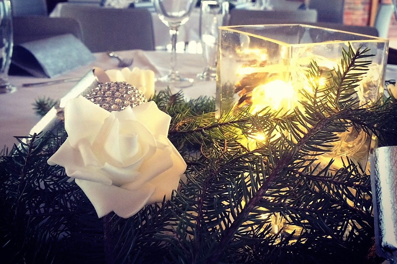 Detaljer: Dekorasjon med lys, blomster og grankvist