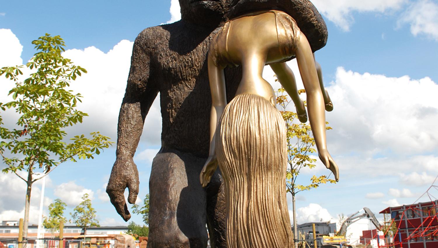 statue av en troll som bærer en kvinne