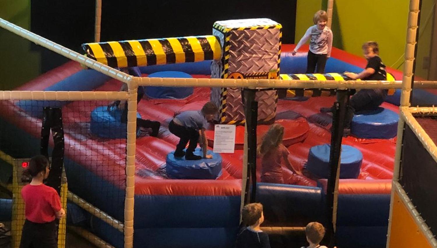 Wipeout, en aktivitet for de litt større barna fra 6 år. Her må barna dukke når stangen kommer. Vi ser fire barn på leken.
