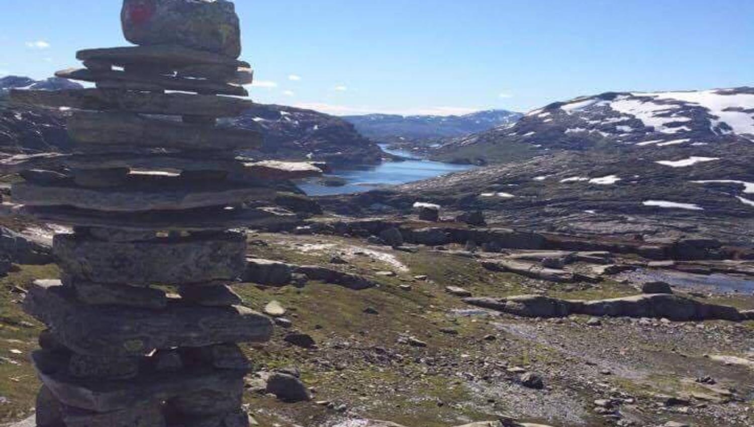 Steinvarde på Hallet grøne med panoramautsikt over fjell og vatn i Hardanger.