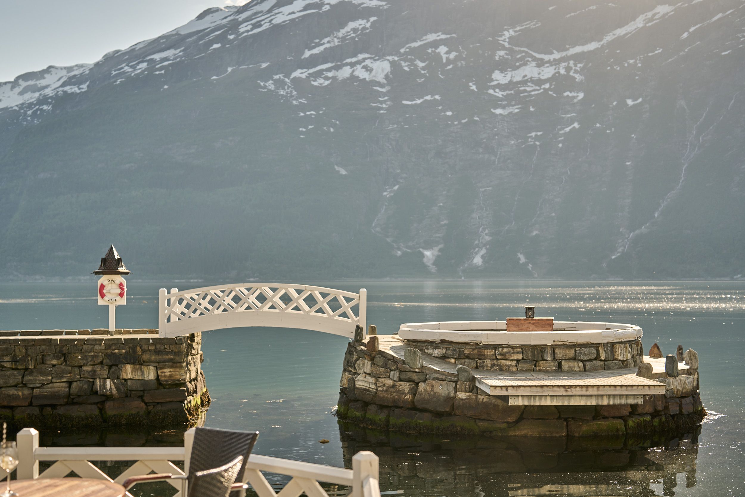 Eksklusivt sitjeområde ved fjorden, omgitt av steinmur og idyllisk natur.