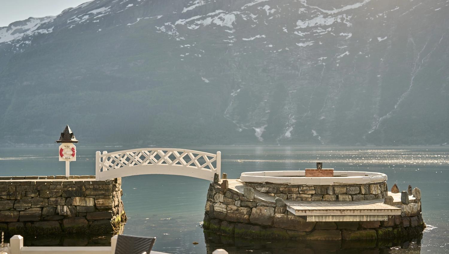 Eksklusivt sitjeområde ved fjorden, omgitt av steinmur og idyllisk natur.