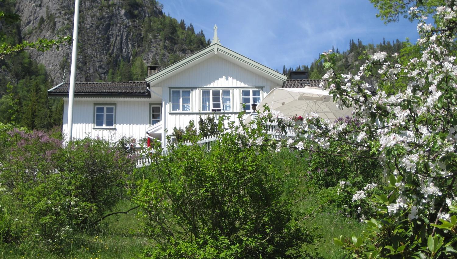 Nutheim Gjestgiveri sett fra hagen om våren
