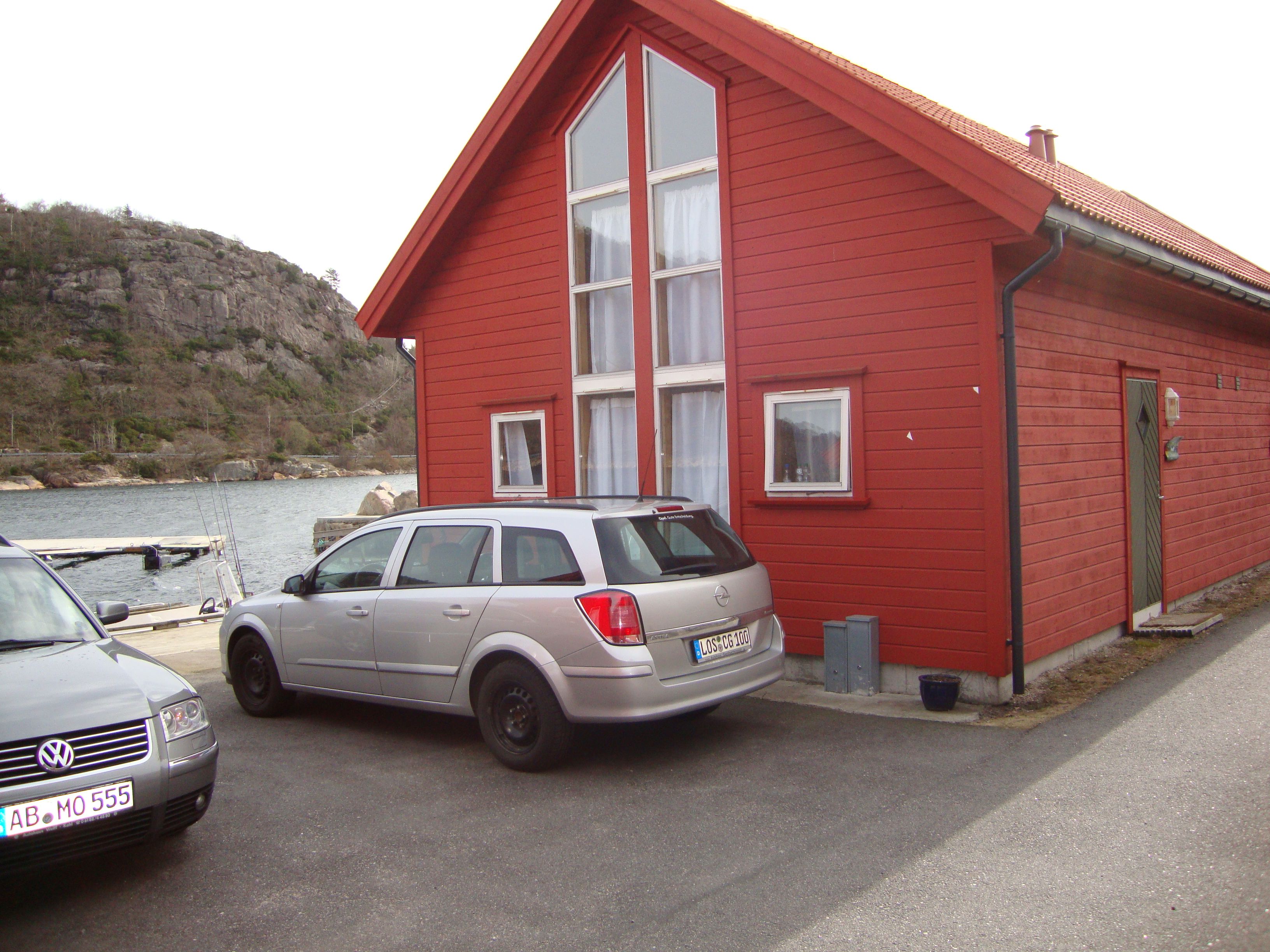 Rødt hytte med to biler parkert vedsidenav